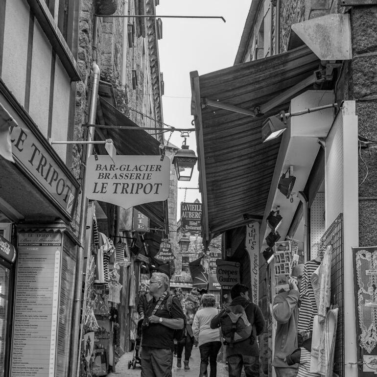 People wandering the narrow alley streets within Mont Saint Michel.