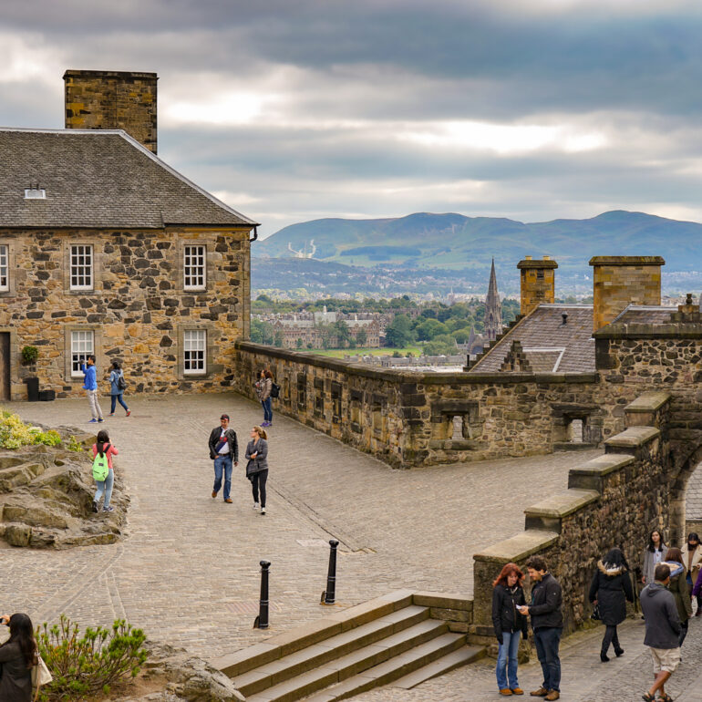 People wander the grounds of Edinburgh Castle on a fall day.