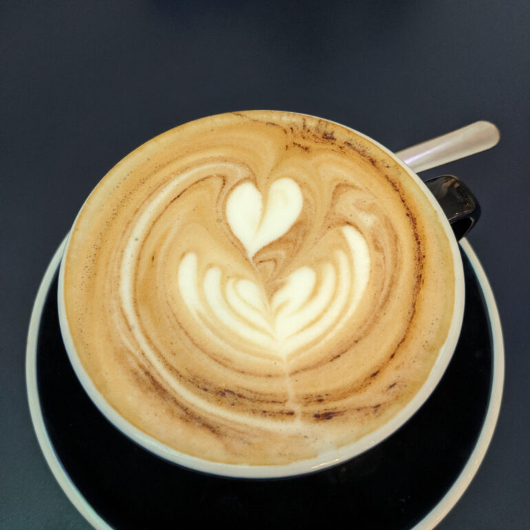 A latte with heart milk art is pictured.